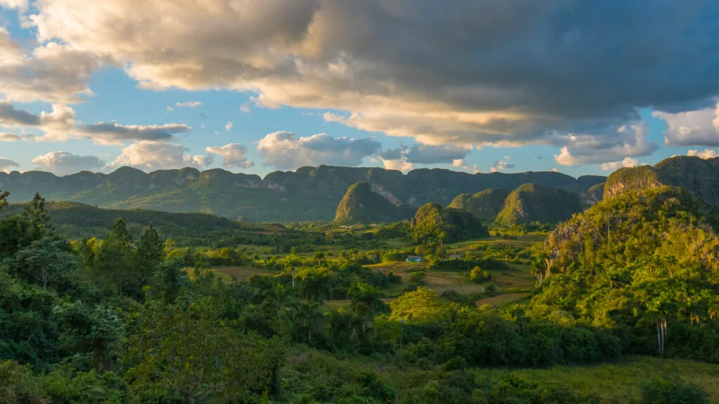 Golden sunset casting shadows across the rolling green hills in Cuba