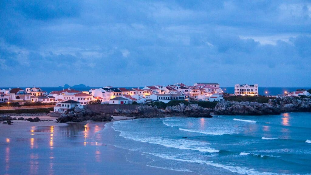 Night view of Baleal with illuminated buildings surrounding the sea and a calm coastal atmosphere