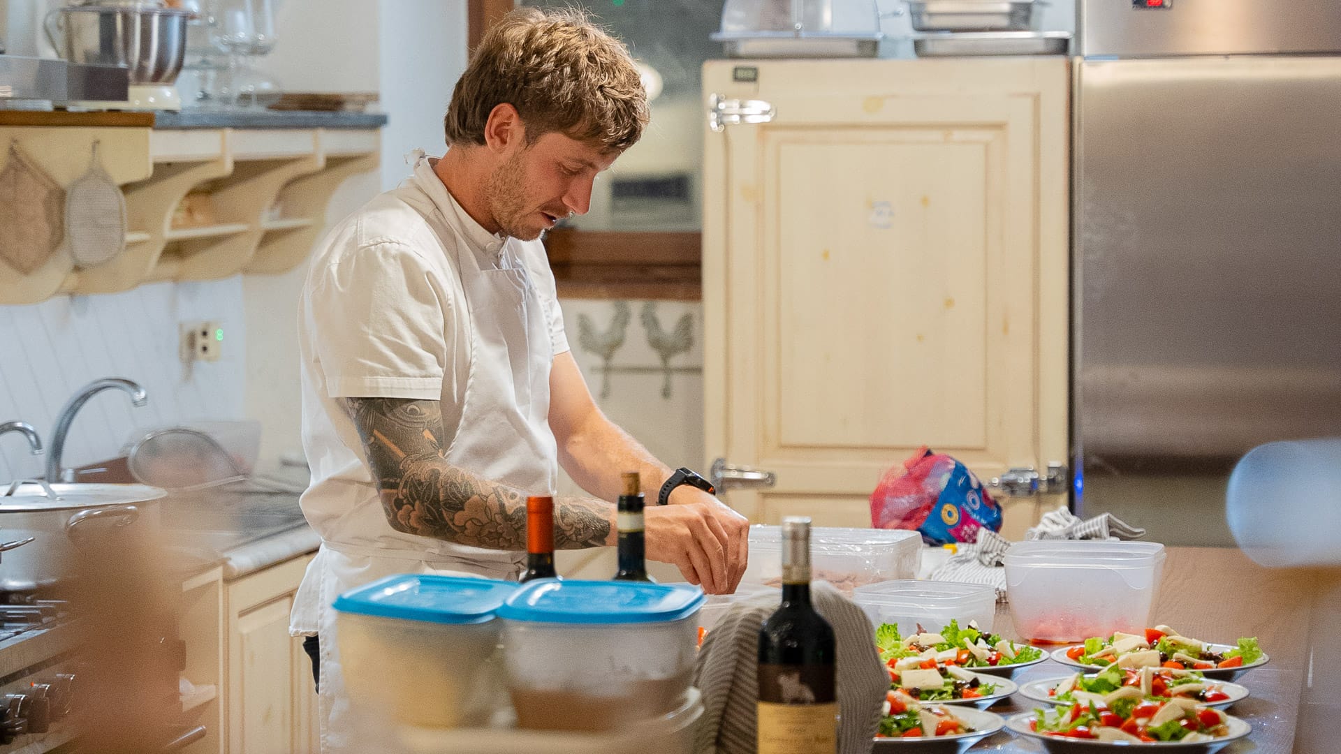 Chef plating colourful salads in a rustic kitchen at inGamba base