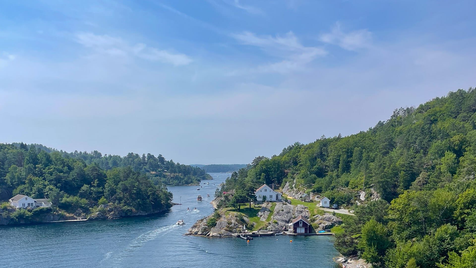 Scenic view of Blindleia fjord with coastal houses and forested hills near Brekkestø in Norway