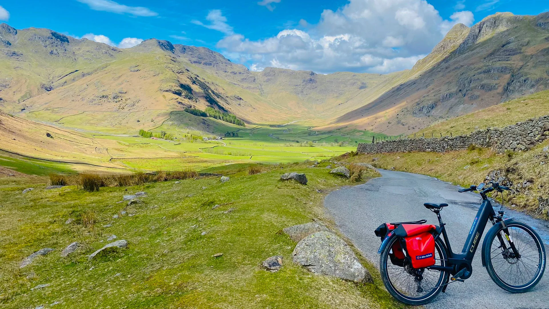 Electric bike on quiet road overlooking Langdale Valley and craggy peaks in the Lake District