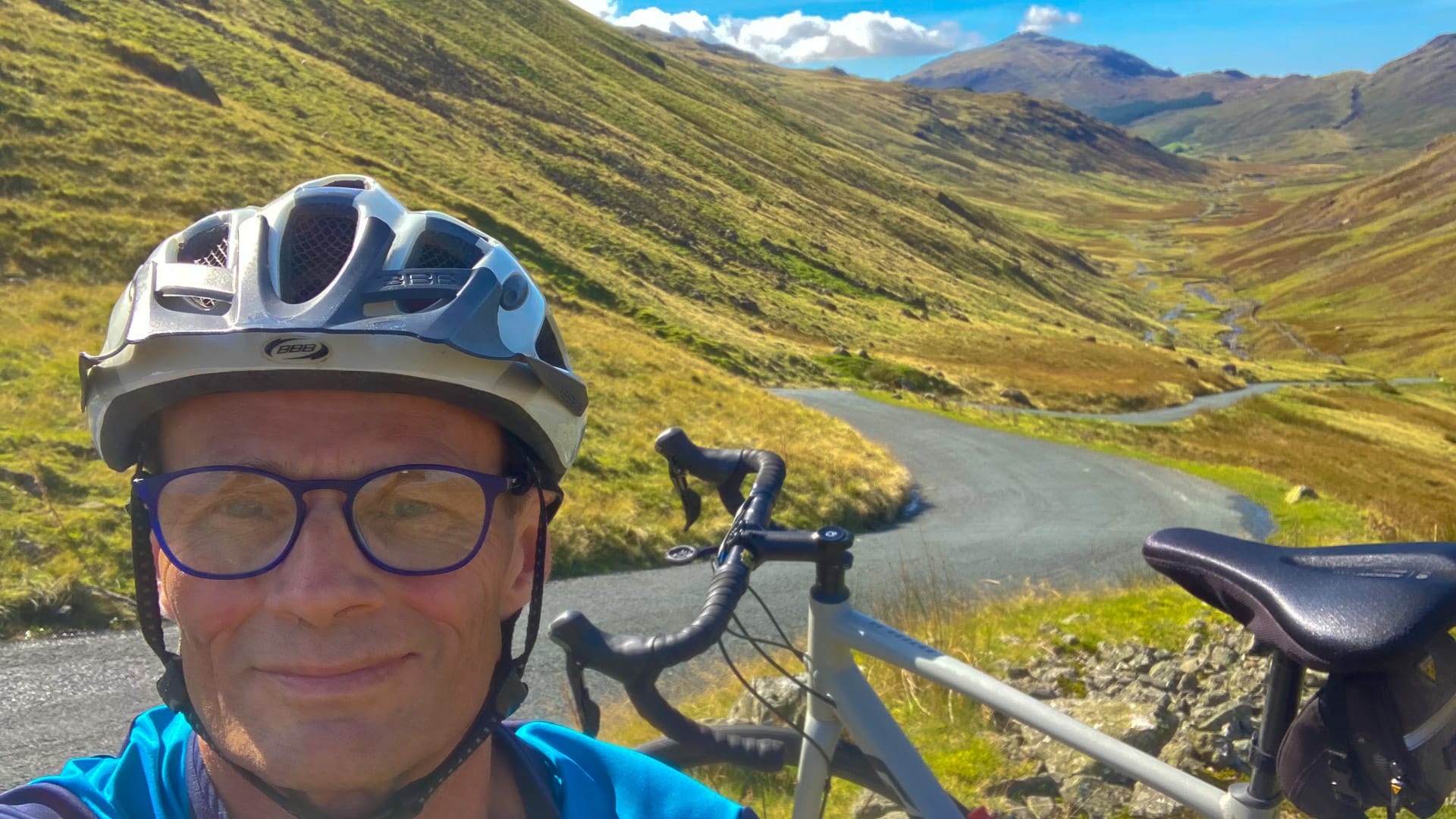 Cyclist taking a selfie above Wrynose Pass in the Lake District sunshine