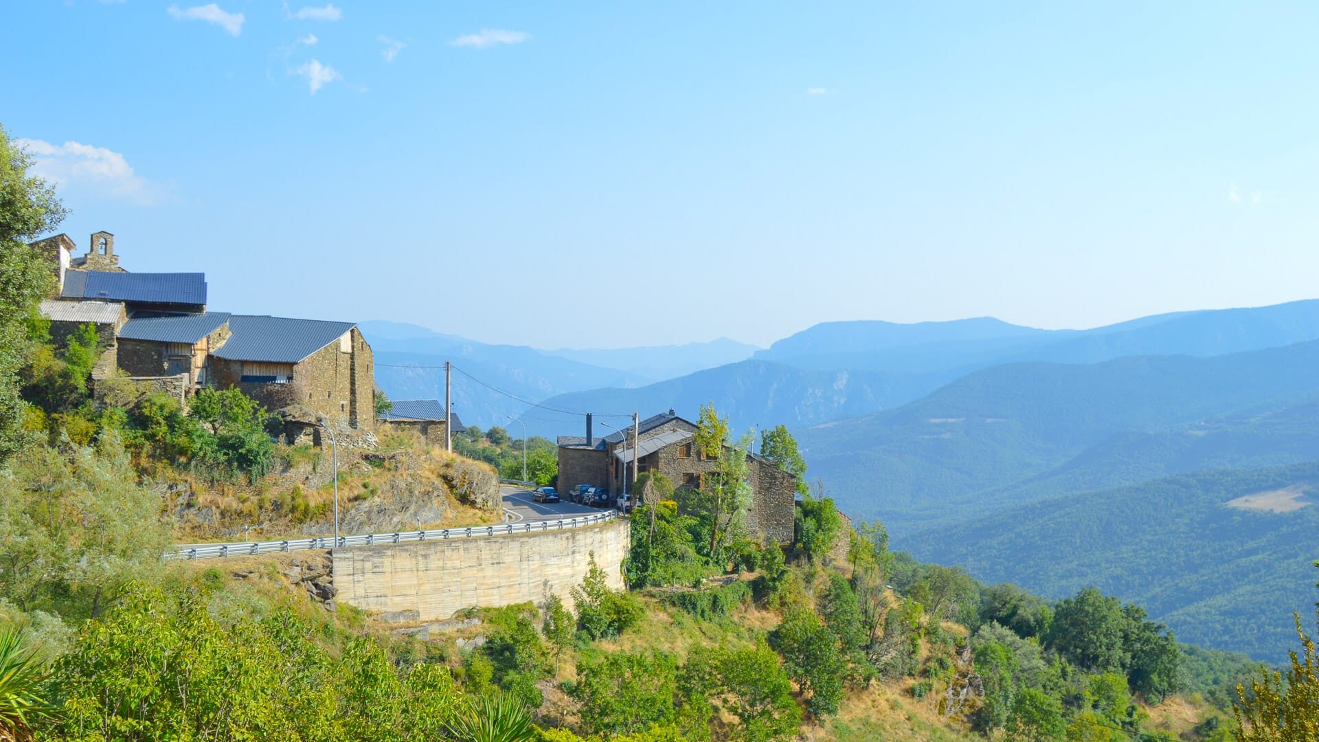Roadside view over Avellanet with stone houses and mountain backdrop