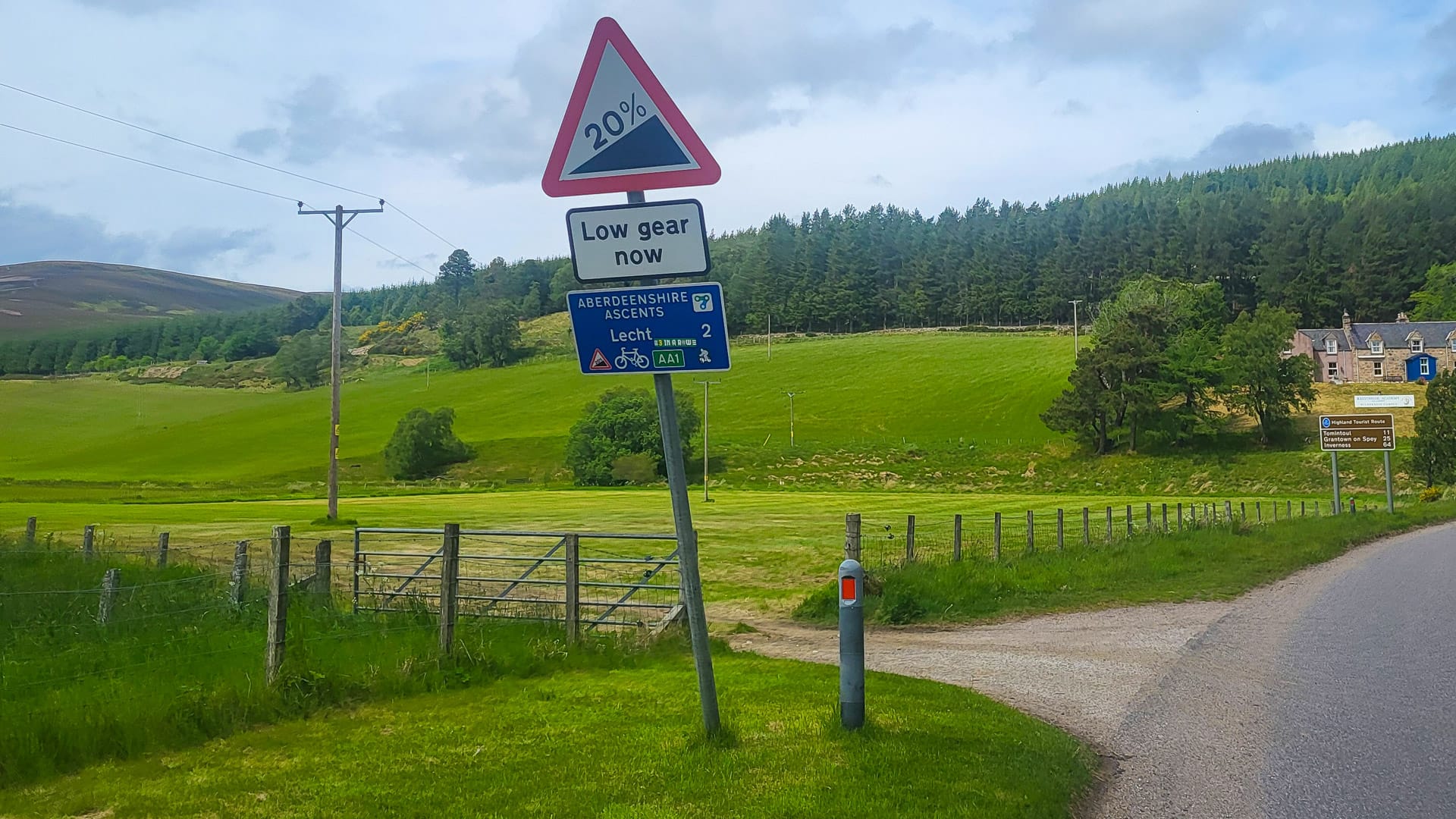 Roadside gradient warning sign with lush green countryside in the background