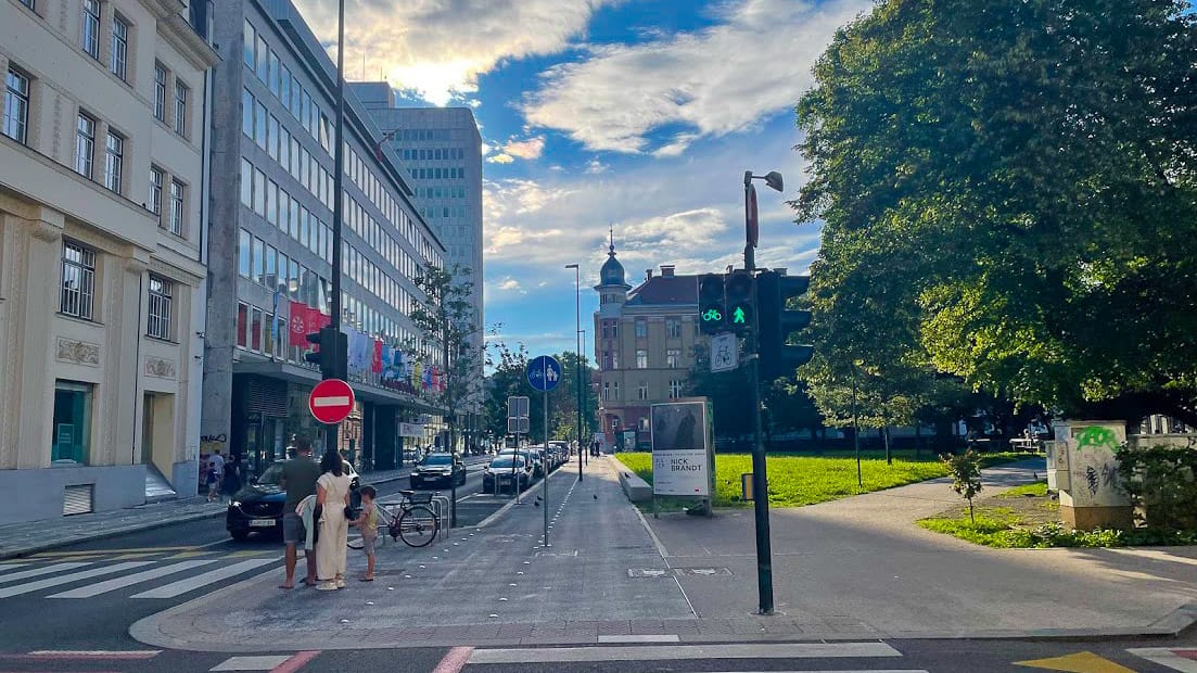 Cycle lane and pedestrian crossing in central Ljubljana with modern buildings and green park