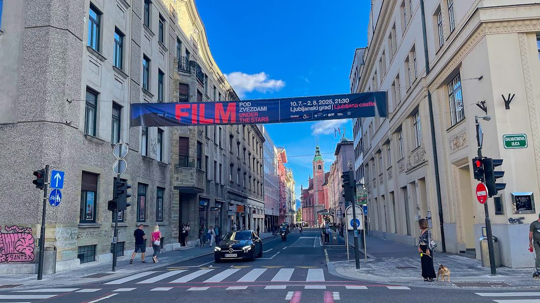 Cycle paths through Ljubljana city centre with film festival banner and historic buildings