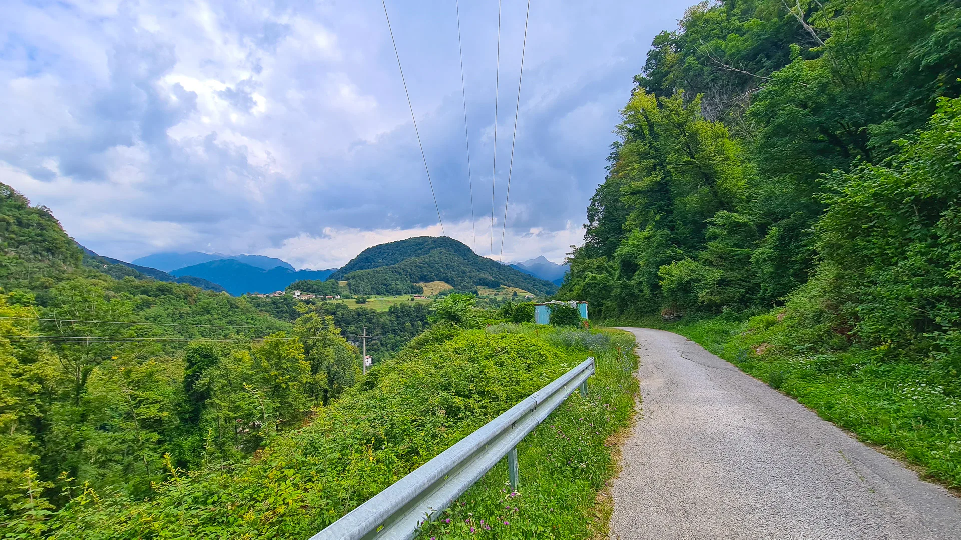 Quiet mountain road winding through forested hills in rural Slovenia’s green landscape