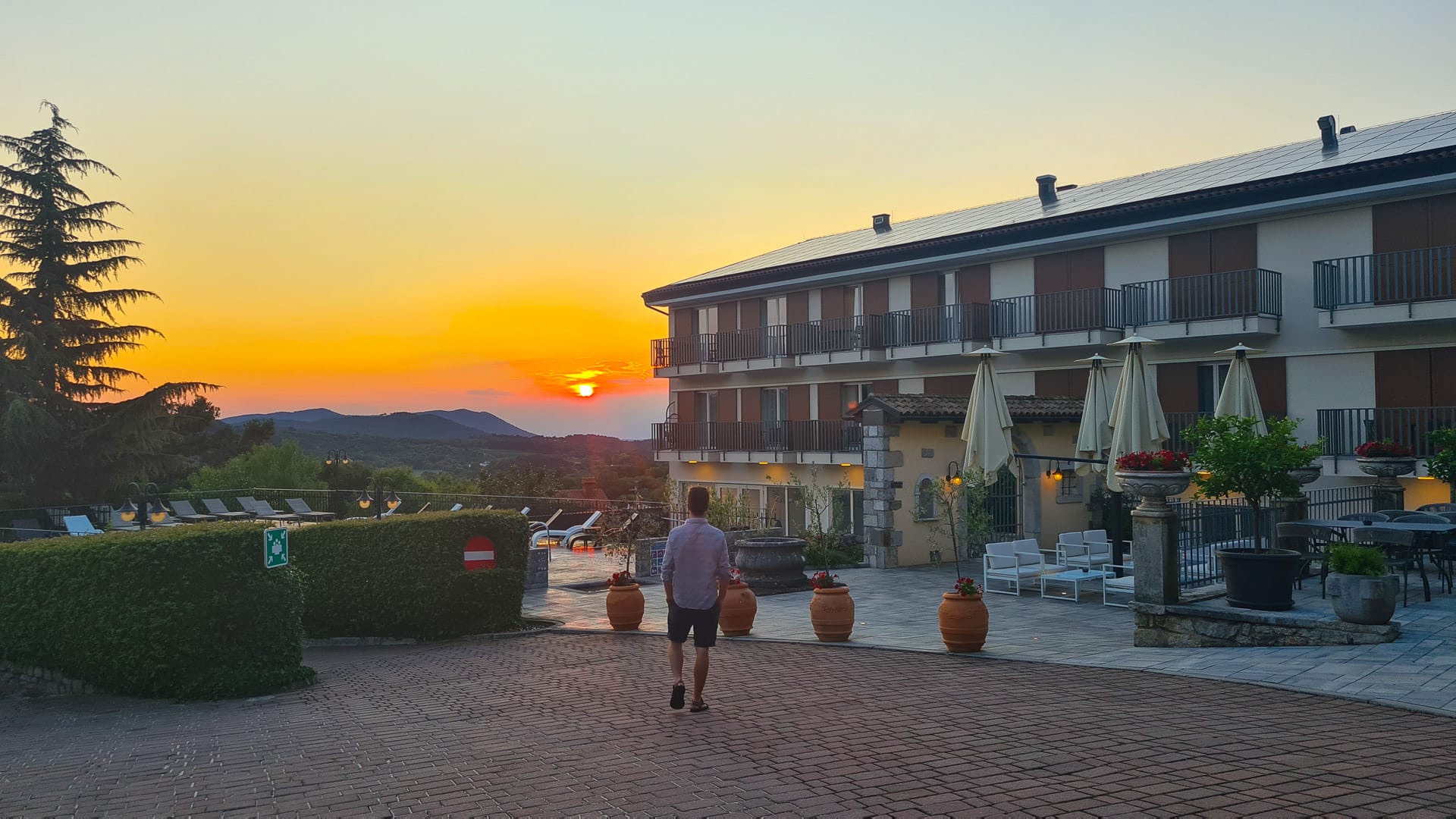 Cyclist walks past hotel terrace at sunset in Slovenia’s wine region