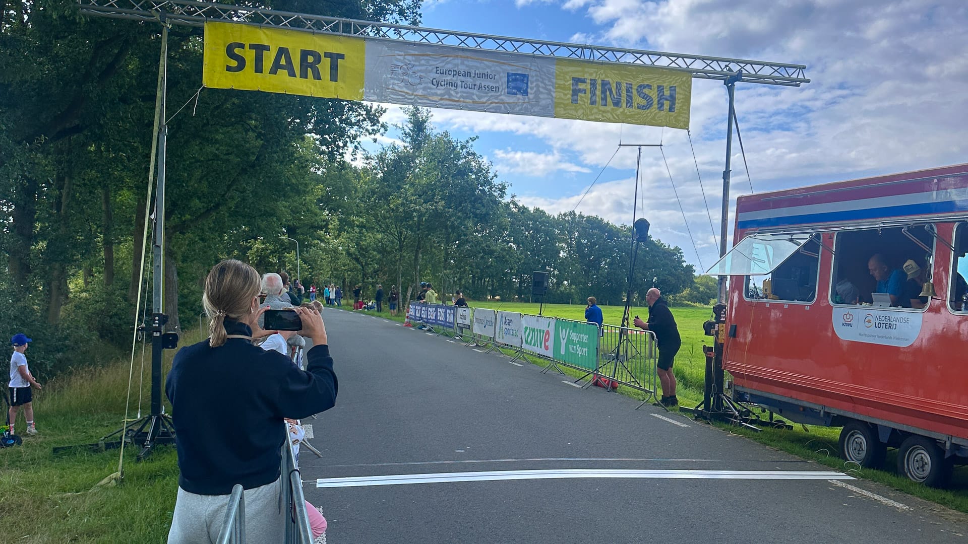 Spectators and officials at the Omloop van Lieveren finish line on a sunny race day