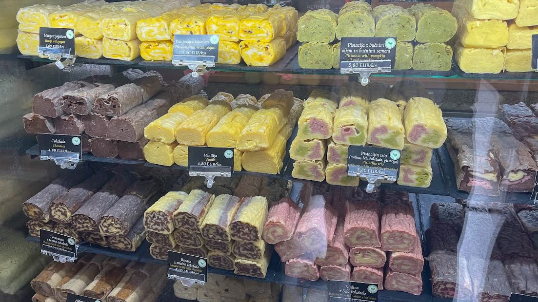 Display of colourful rolled dumplings in a Ljubljana bakery window