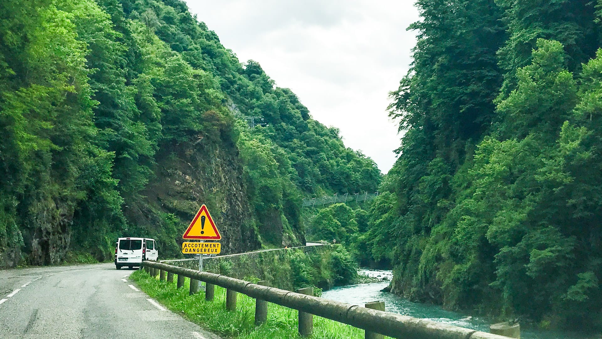 Rockfall warning sign beside riverside gorge road to Col du Tourmalet