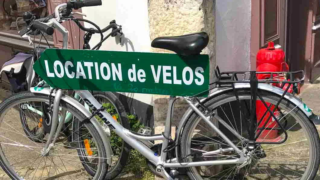 Bicycle displaying \"Location de Vélos\" sign for rentals