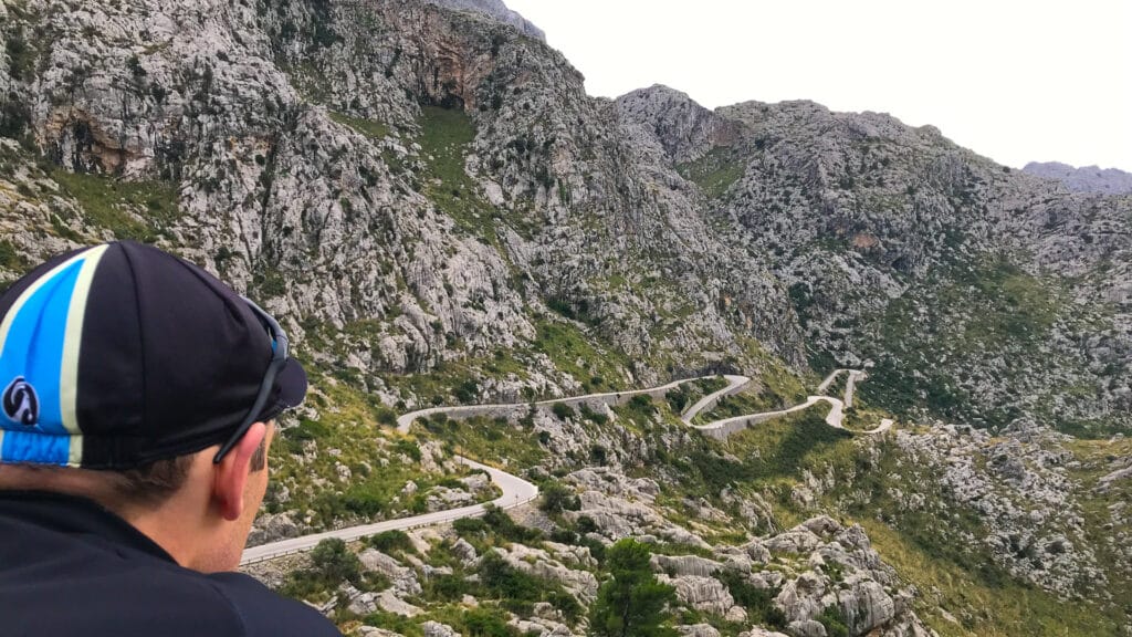 Cyclist cycling Mallorca looking down to famous cycle Mallorca route of Sa Calobra