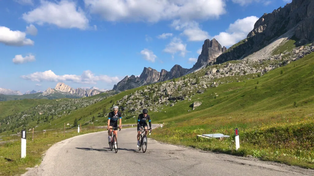Cyclists on mountain road near jagged peaks of Passo Giau in the Dolomites