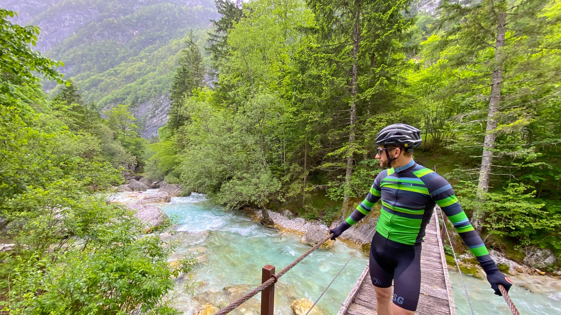 Cyclist on a bridge out while cycling Slovenian alps