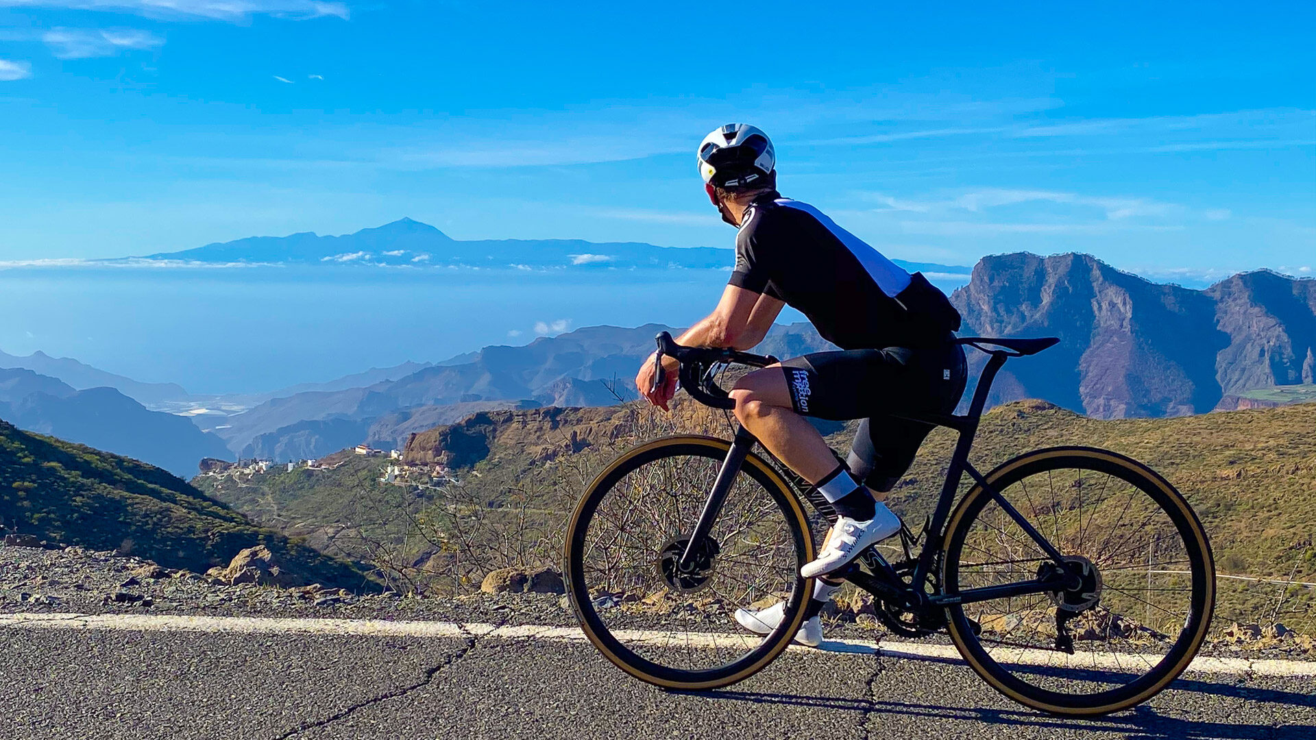 Cyclist at summit of Valley of the Tears cycling route admiring view