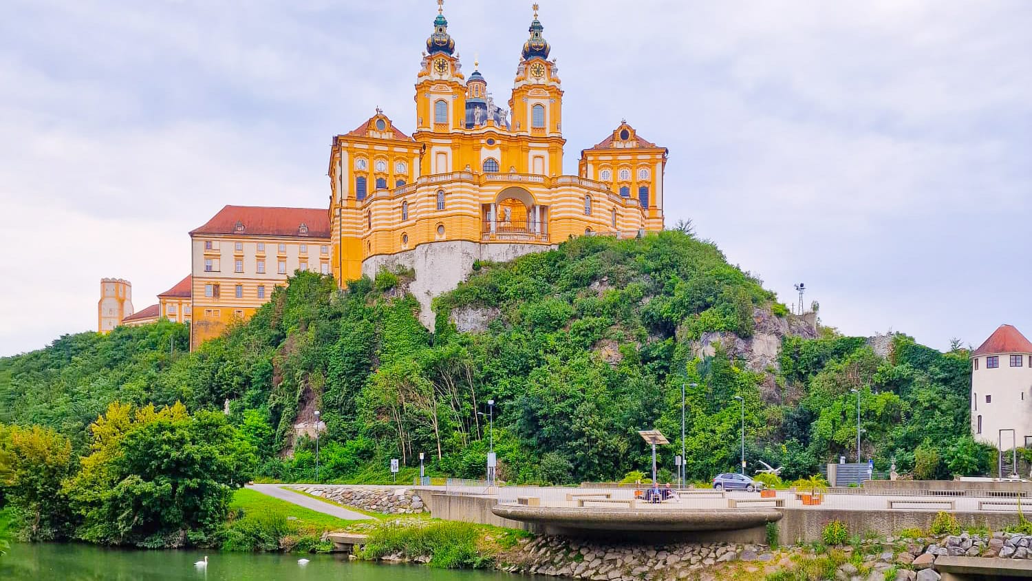 Melk Abbey perched on a hill above the Danube River in Austria surrounded by greenery