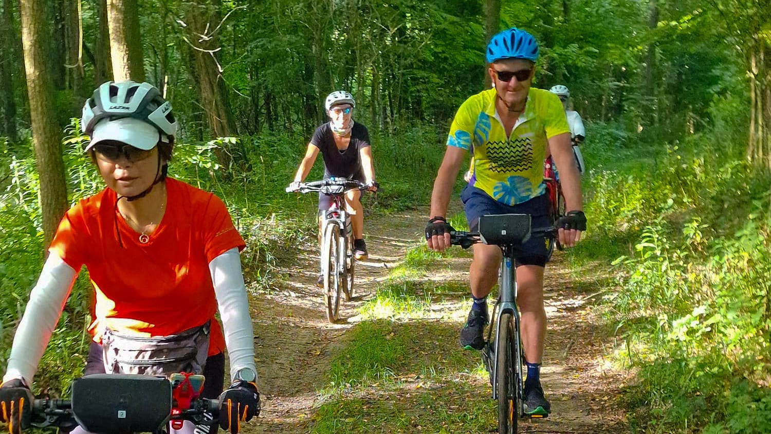 Cyclists riding along a shaded woodland trail in Hungary, part of the scenic Danube cycling route