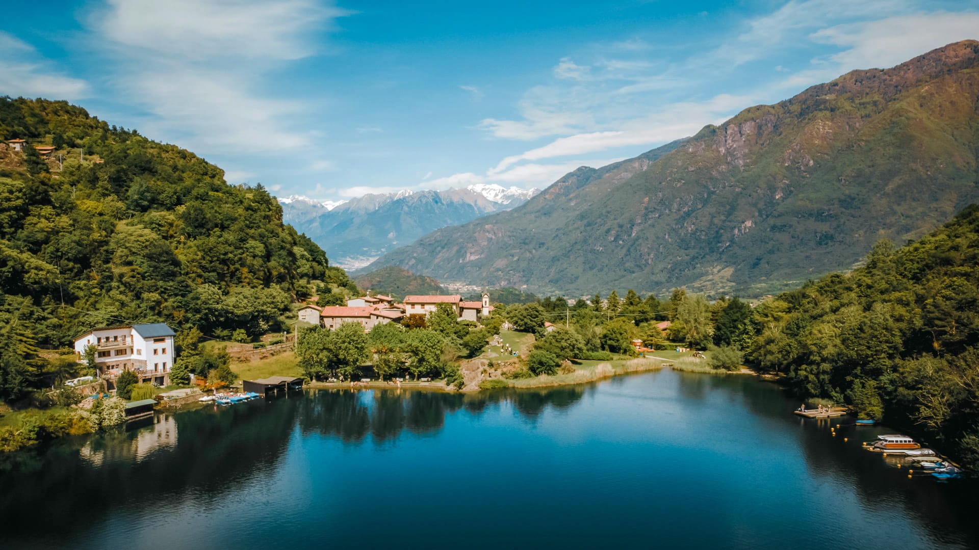 Lake Moro nestled among lush green mountains and a small Italian village
