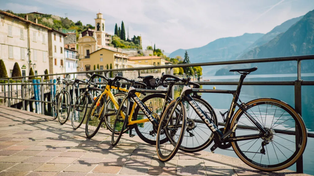 Row of bicycles parked along a lakeside promenade with historic buildings and mountains in the background at Lake Iseo