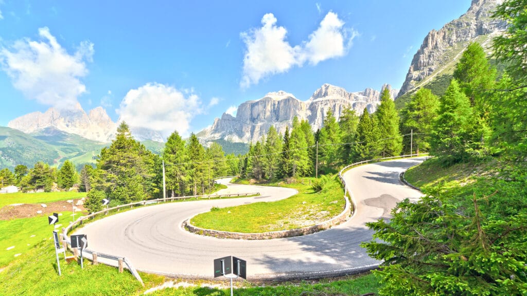Hairpin bend climbing through alpine scenery on Passo Pordoi in the Dolomites