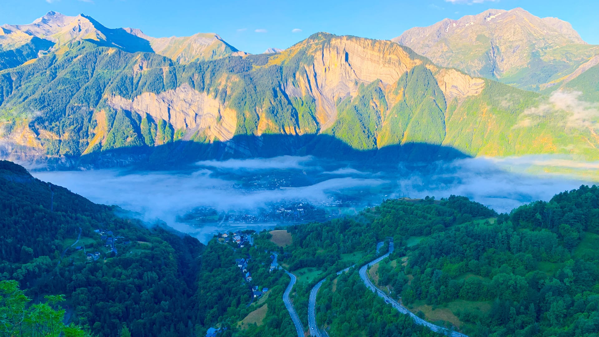 View of Alpe d’Huez switchbacks and valley village from above, French Alps