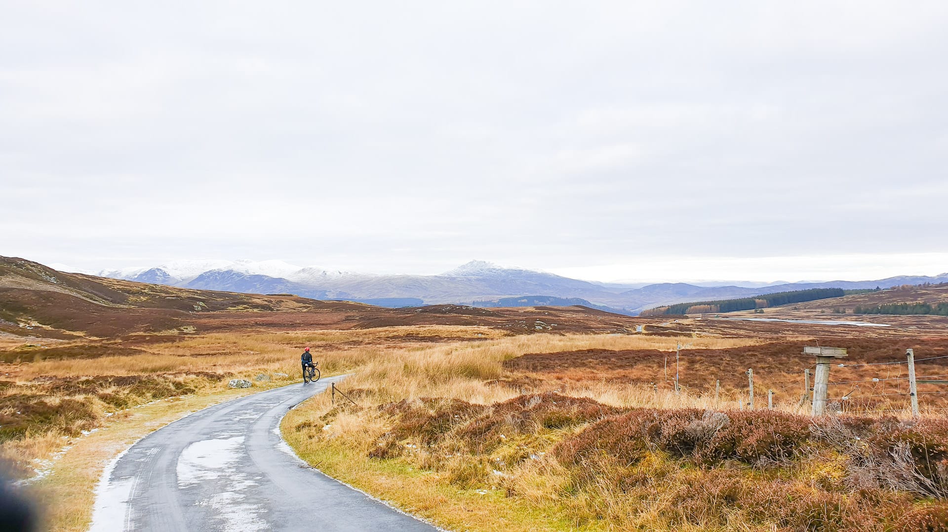 Cyclist on a narrow road with views climbing Glen Quaich