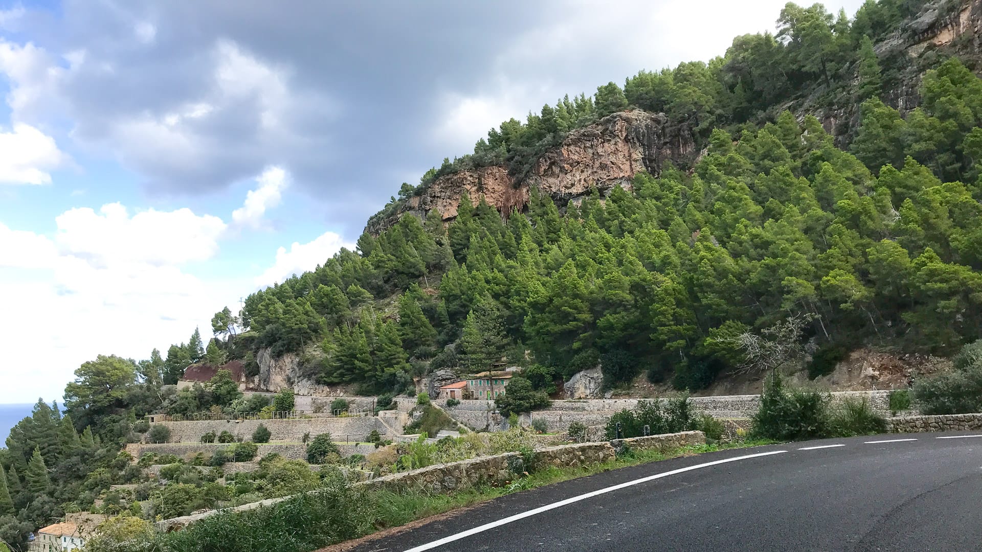 Terraced green hills and stone houses overlooking the sea near Banyalbufar, Mallorca