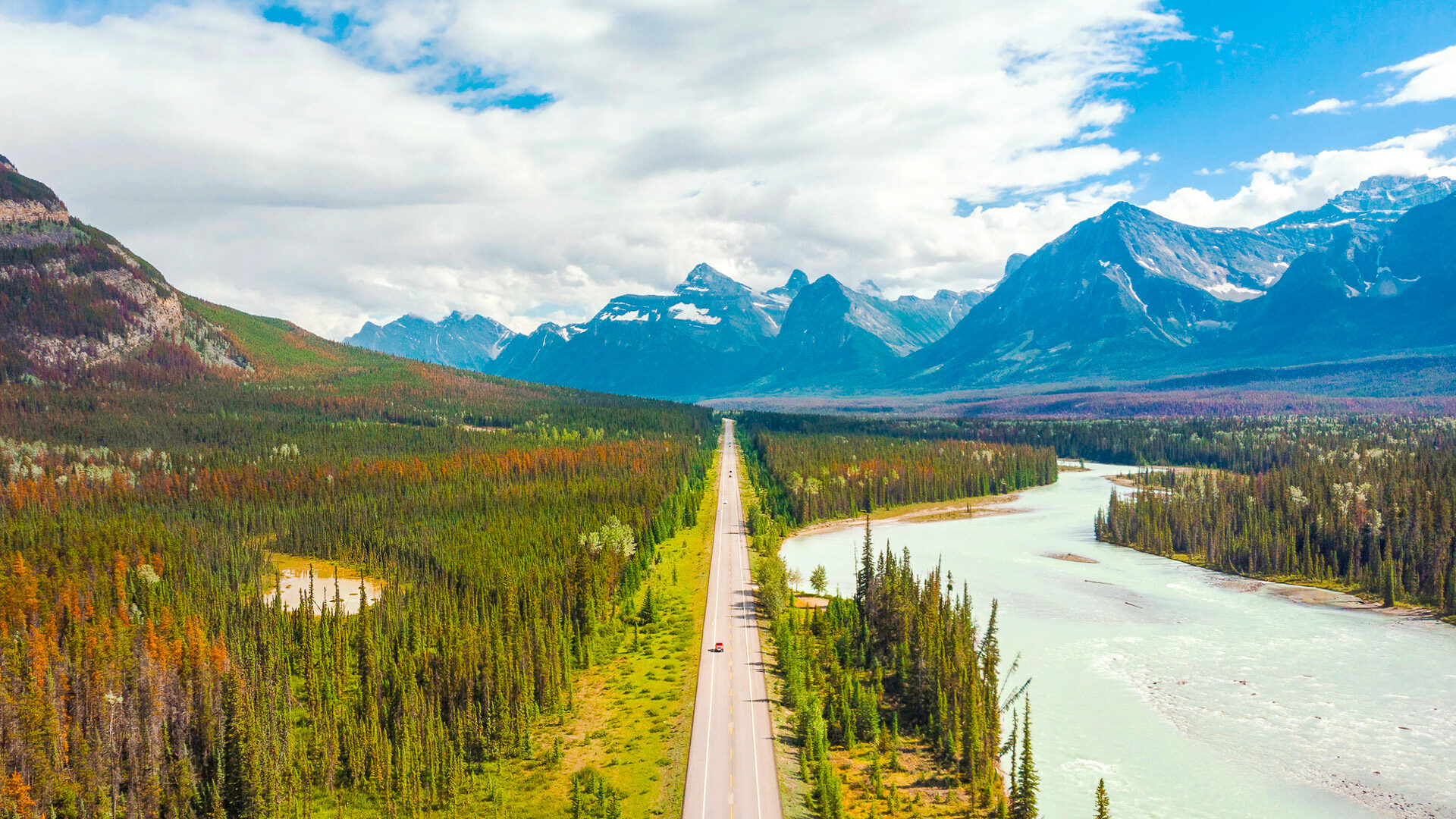 Aerial view of vehicles on scenic Icefields Parkway highway between Banff and Jasper National Parks during summer in Alberta, Canada.