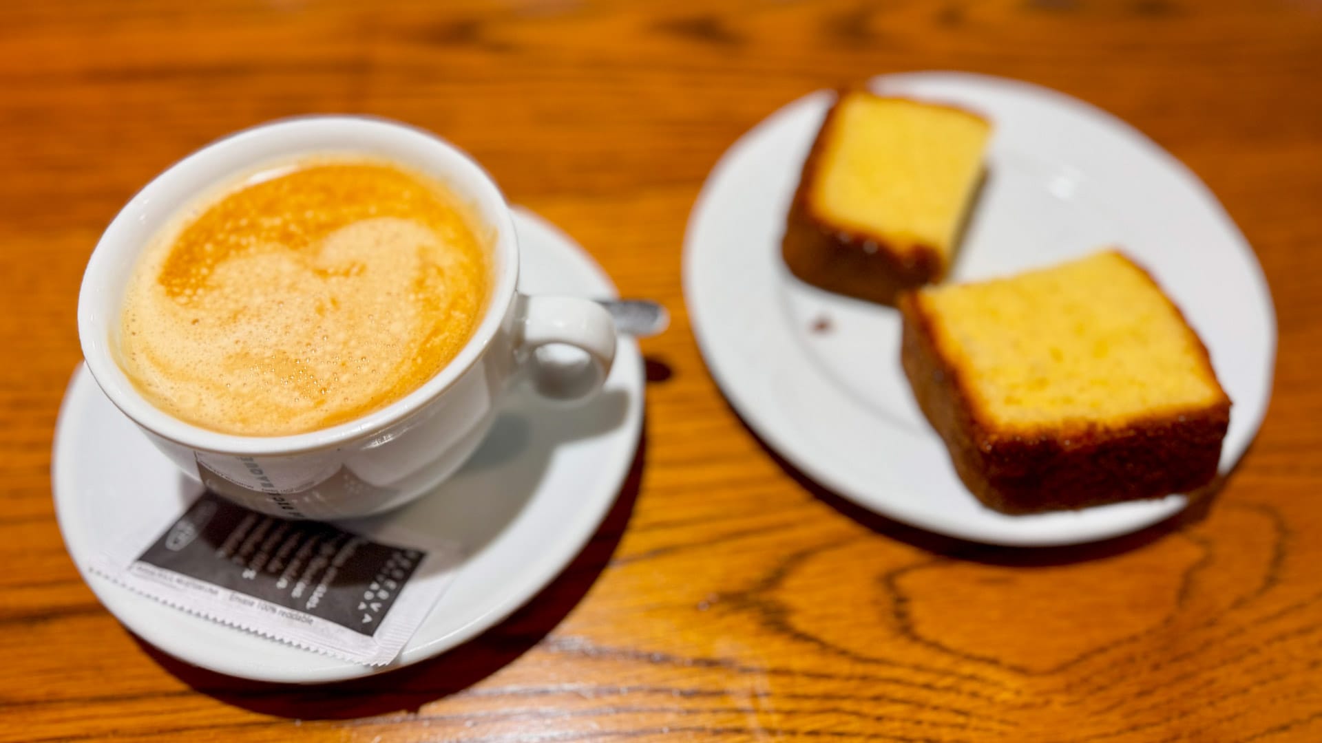 Cup of coffee with two slices of cake on a wooden table before climbing during Desertus Bikus