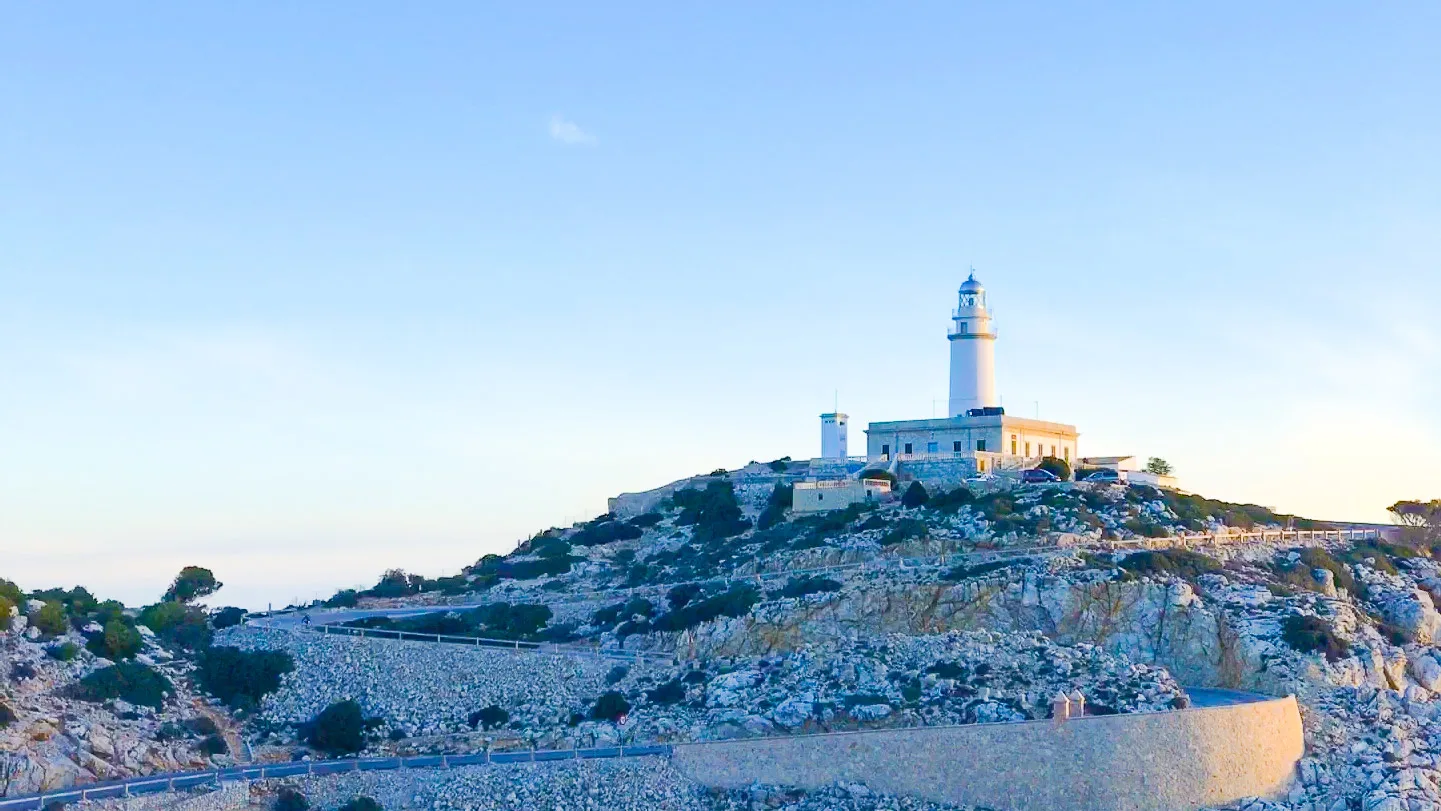 Cap de Formentor lighthouse above rocky headland at sunset, Mallorca