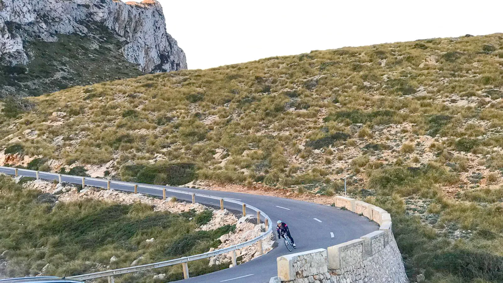 Cyclist descending a tight hairpin on the Cap de Formentor road, Mallorca