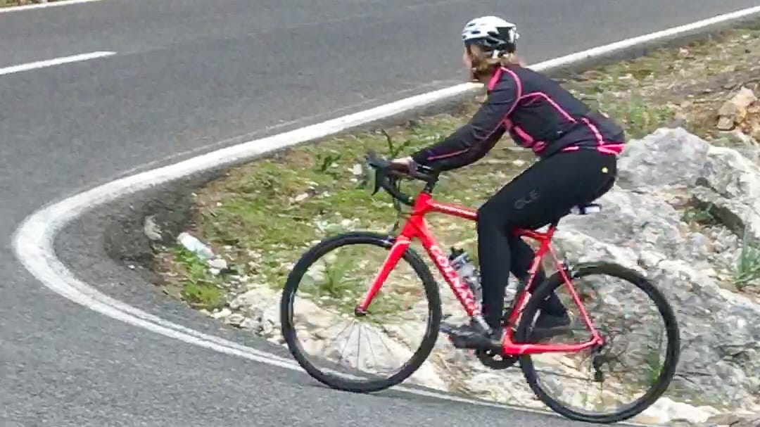 Cyclist climbing a sharp bend on the Coll de Femenia ascent in Mallorca