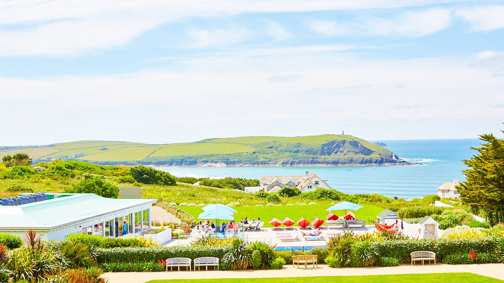 Hotel terrace with sun loungers and umbrellas overlooking the sea and coastline near Padstow Cornwall