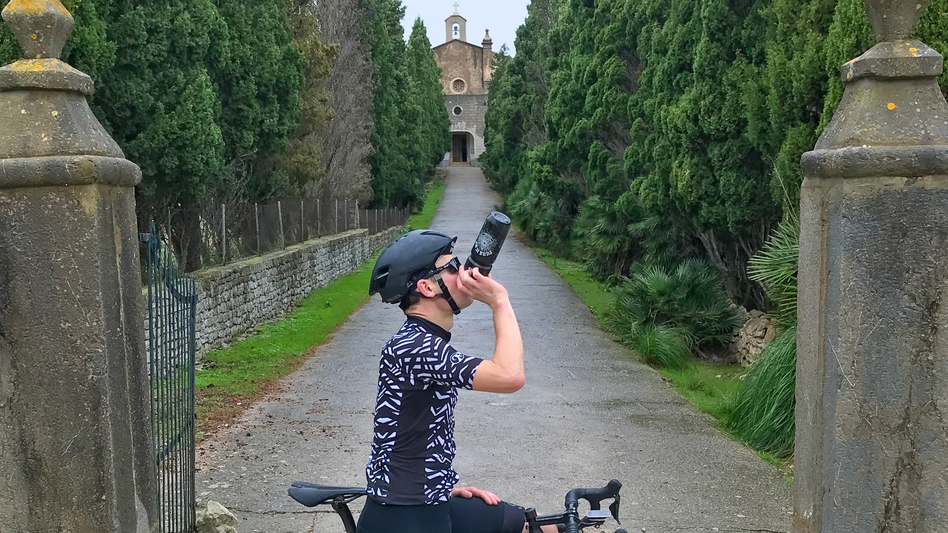 Cyclist in front of drive leading to Betlem monastery Mallorca