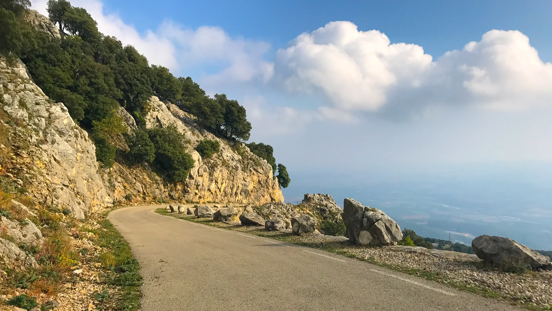Winding mountain road carved into rocky cliffs on the Mare de Déu del Mont route