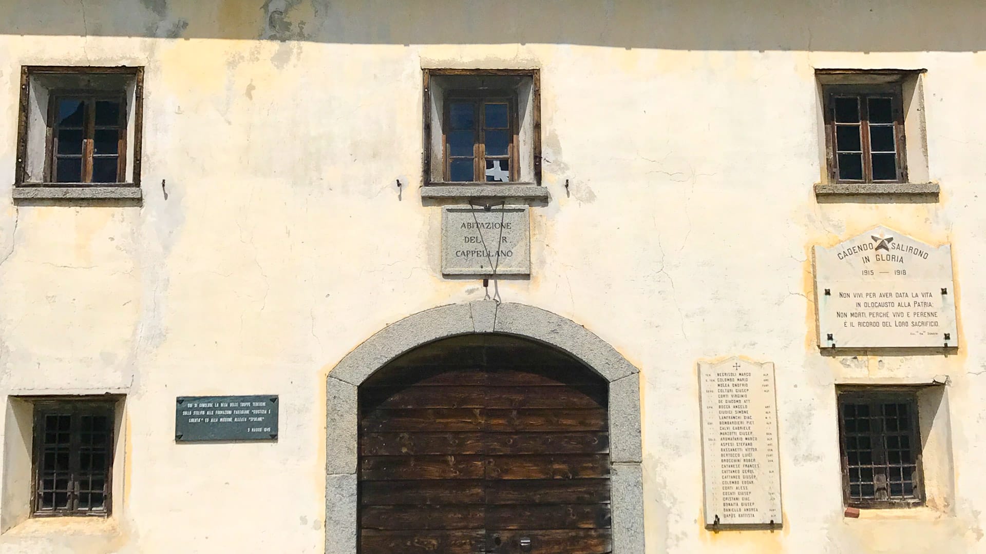 Facade of chapel at Passo dello Stelvio with WWI memorial plaques and inscription for the chaplain’s residence