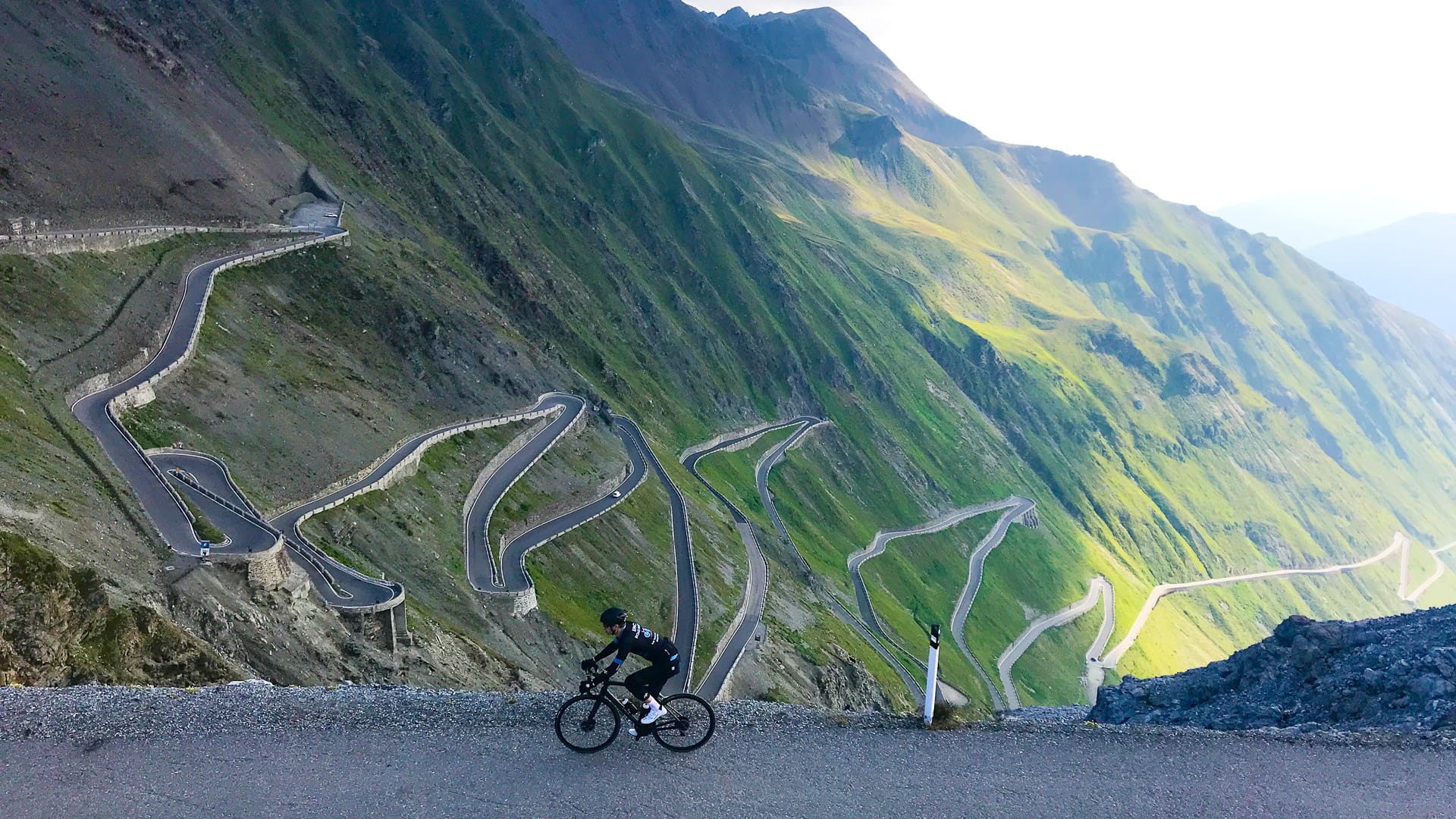 Cyclist at top of Passo dello Stelvio hairpins