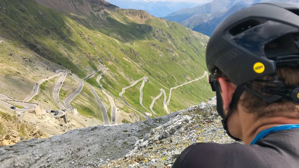 Passo dello Stelvio cycling cyclist admires view from top of Passo dello Stelvio
