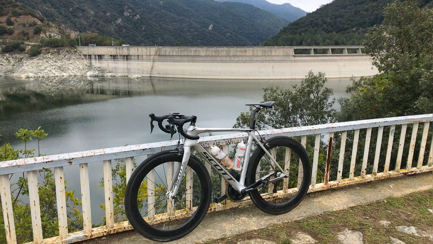 Road bike leaning on a railing overlooking the Susqueda dam reservoir near Girona