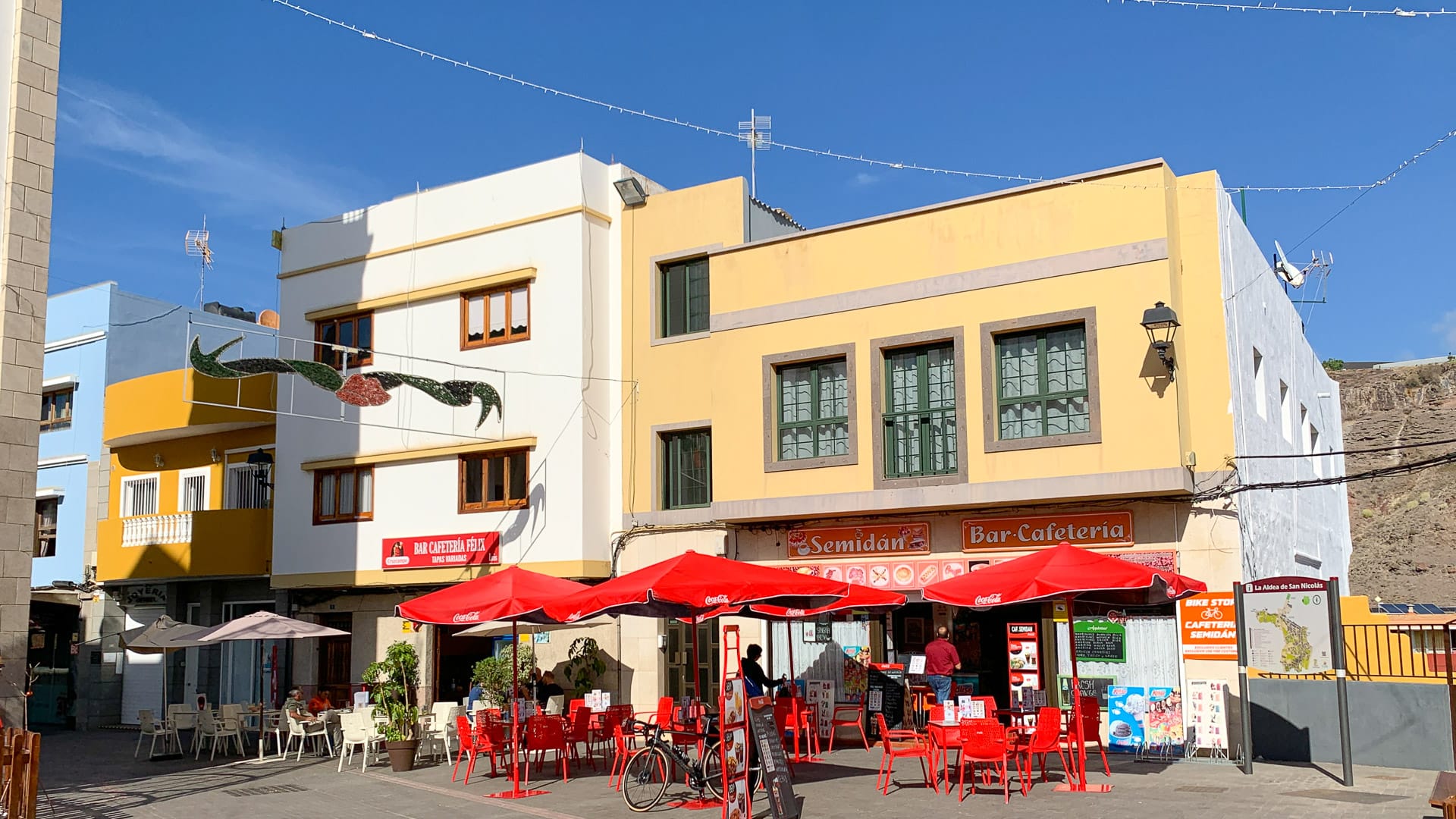 Traditional village square with colourful buildings and red parasols in inland Gran Canaria