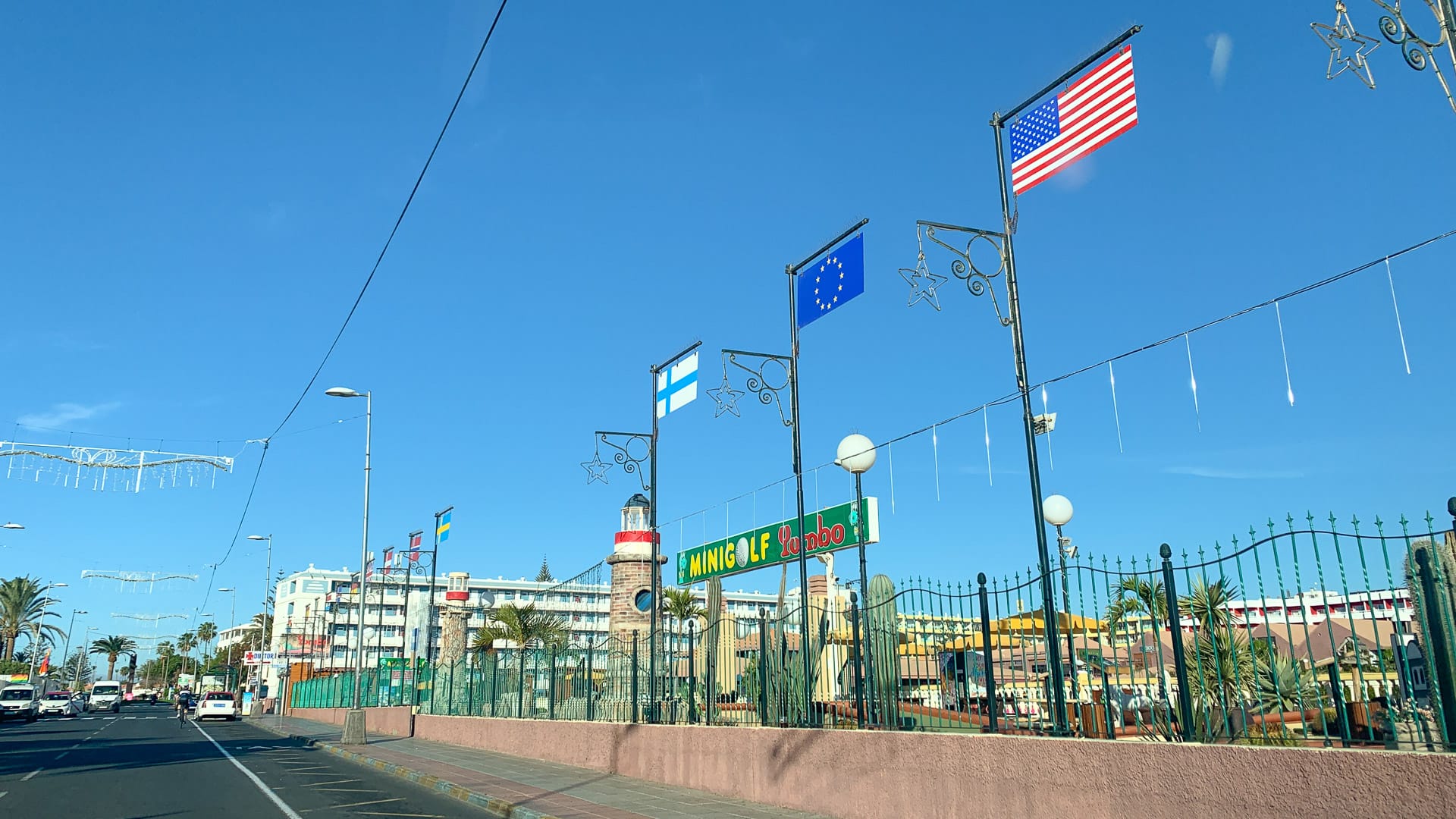 Row of international flags lining a sunny street in Gran Canaria