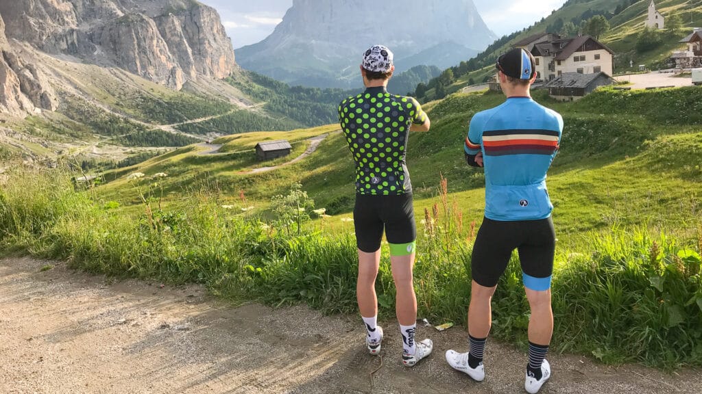 Two road cyclists looking at the view whilst cycling in the Dolomites, Italy