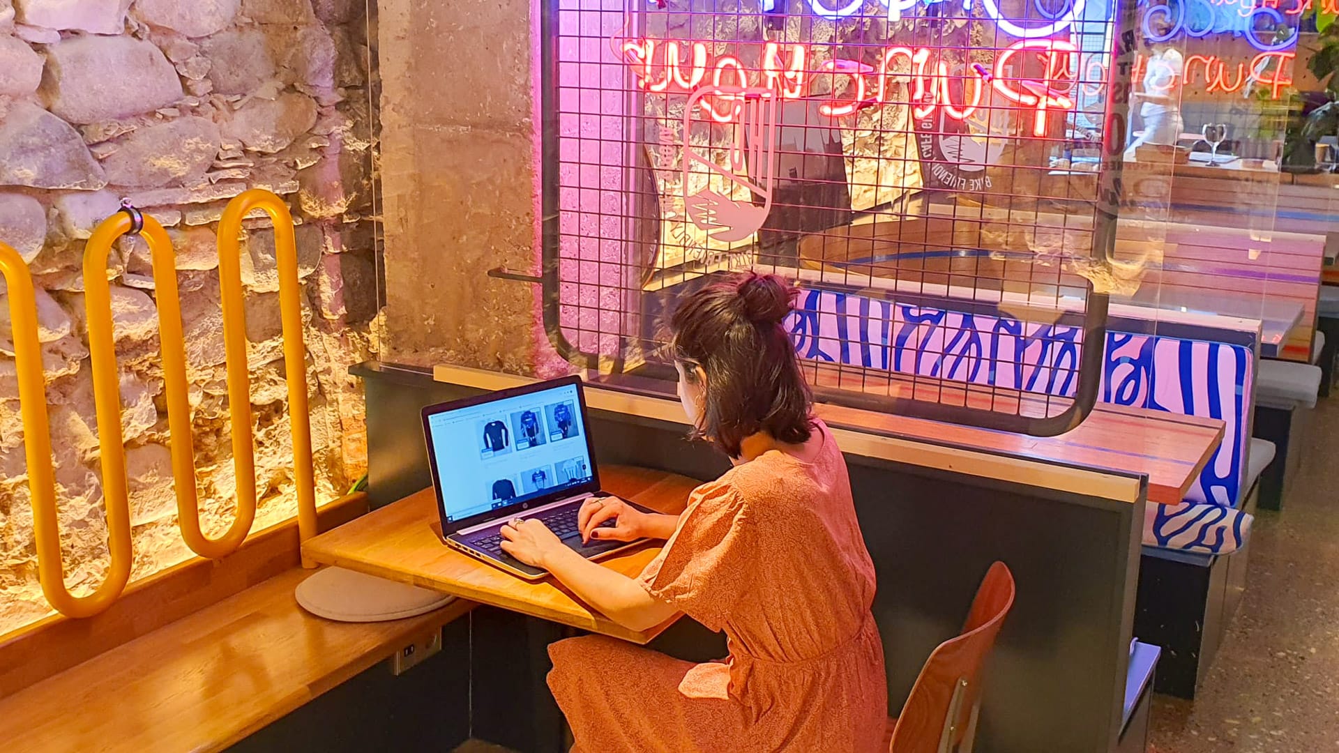 Woman running Pro Cycling Outlet cycling merchandise shop from computer