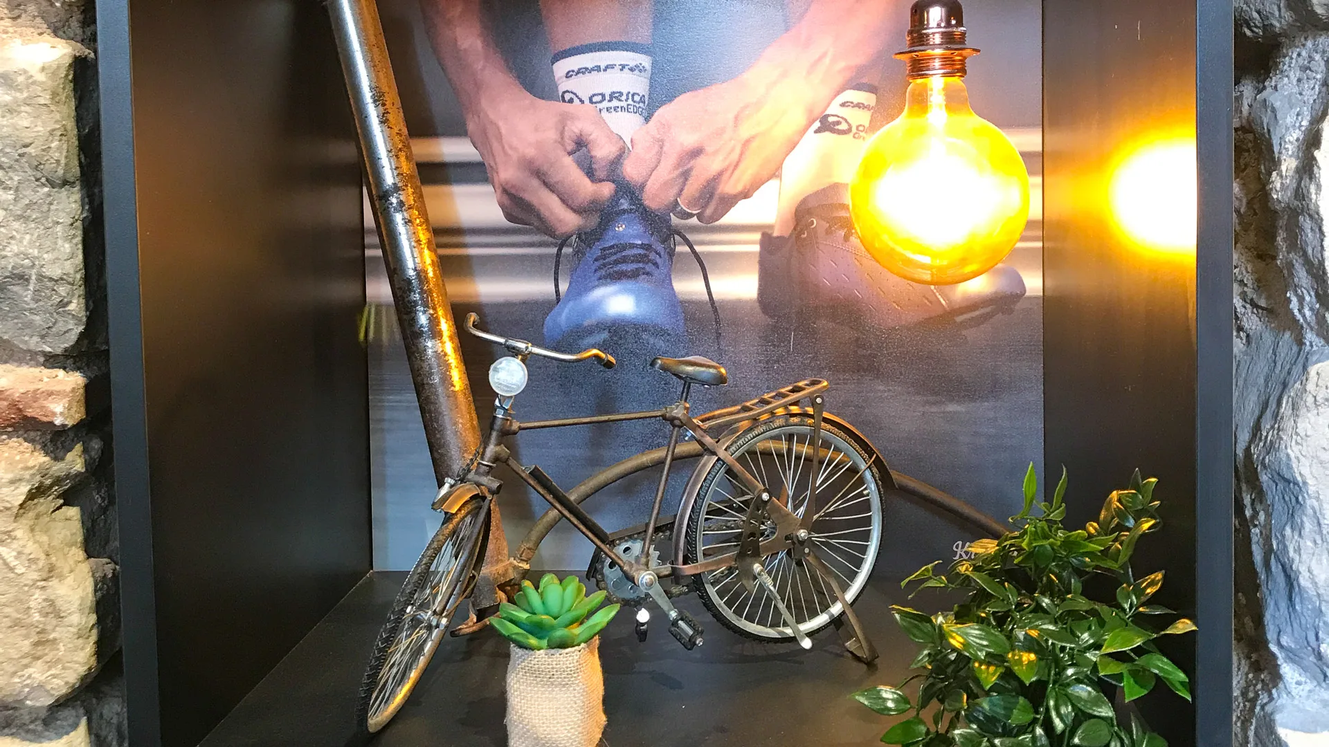 Decorative shelf at La Fábrica in Girona with bike model, plants and retro cycling photo