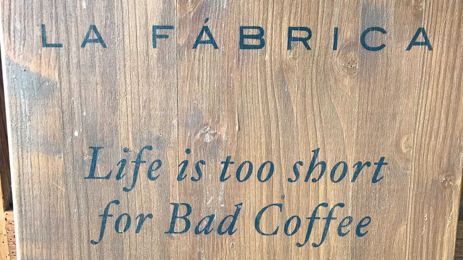Wooden sign at La Fábrica café in Girona reading 'Life is too short for Bad Coffee'