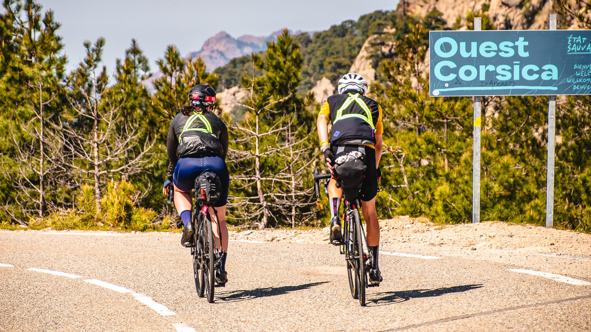 Two cyclists climbing the Vergio pass in Corsica chatting on the road during the BikingMan Corsica ultracycling race