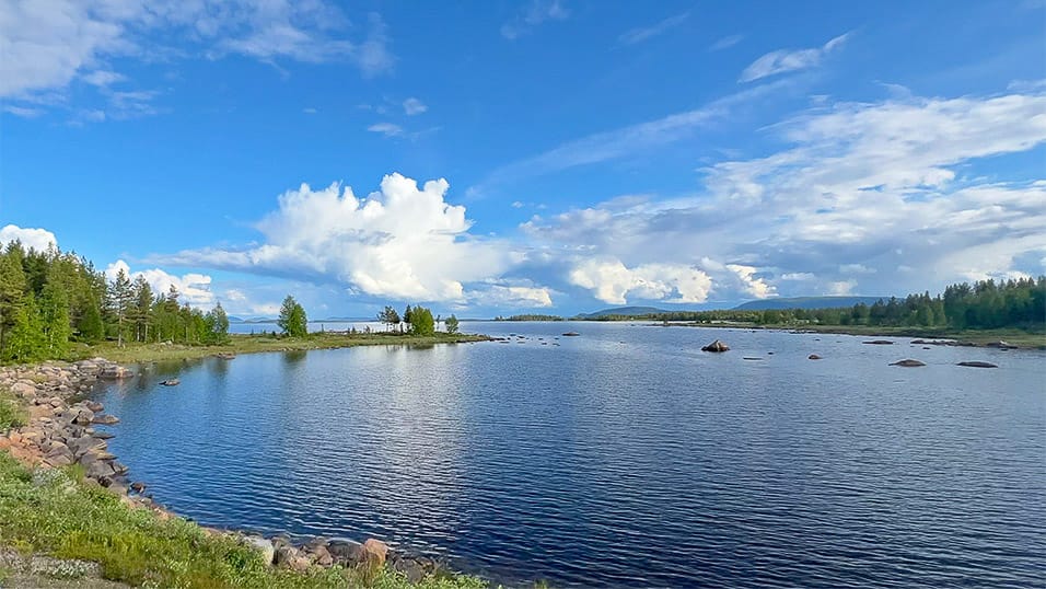 Rocky lake inlet in Västerbotten Sweden under dramatic storm clouds with calm reflective water