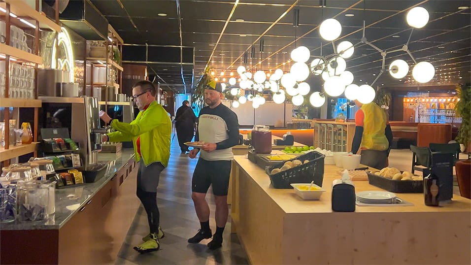 Cyclists grabbing breakfast at a hotel buffet in Umeå before riding the Midnight Sun Randonnée