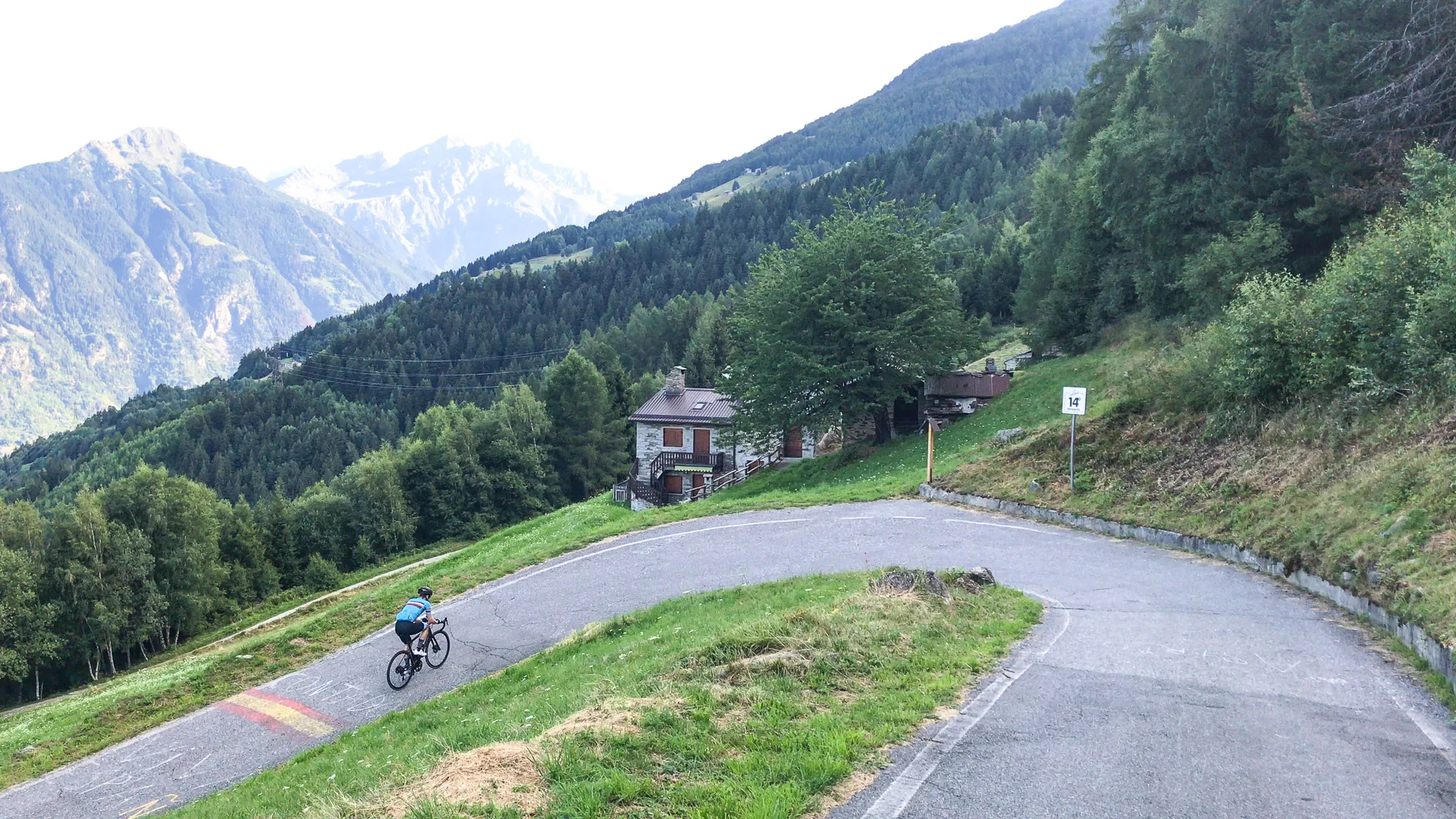 Cyclist riding a switchback on Passo Mortirolo in Lombardy, Italy